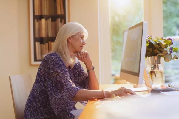 Senior woman working at computer in home office