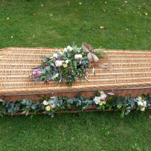 Somerset willow coffin with flower garland and sheath