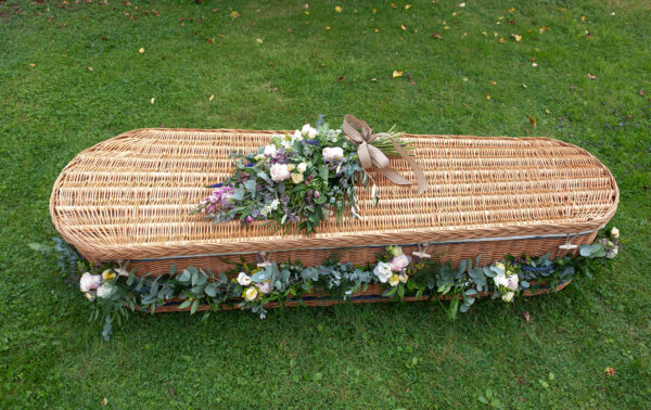 Somerset willow coffin with flower garland and sheath